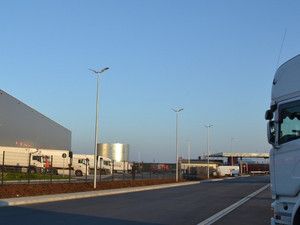 Penny Logistikzentrum. Graue Halle mit Penny-Logo drauf. Davor ein LKW.