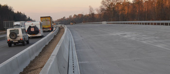 Pfuhler Rinne verlegt an der Autobahn-Bucht. Auf der gegenüberliegenden Fahrbahn fahren Autos.