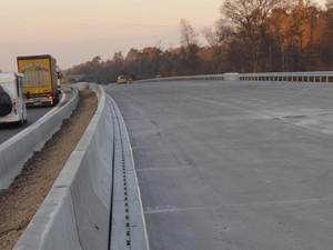 Pfuhler Rinne verlegt an der Autobahn-Bucht. Auf der gegenüberliegenden Fahrbahn fahren Autos.
