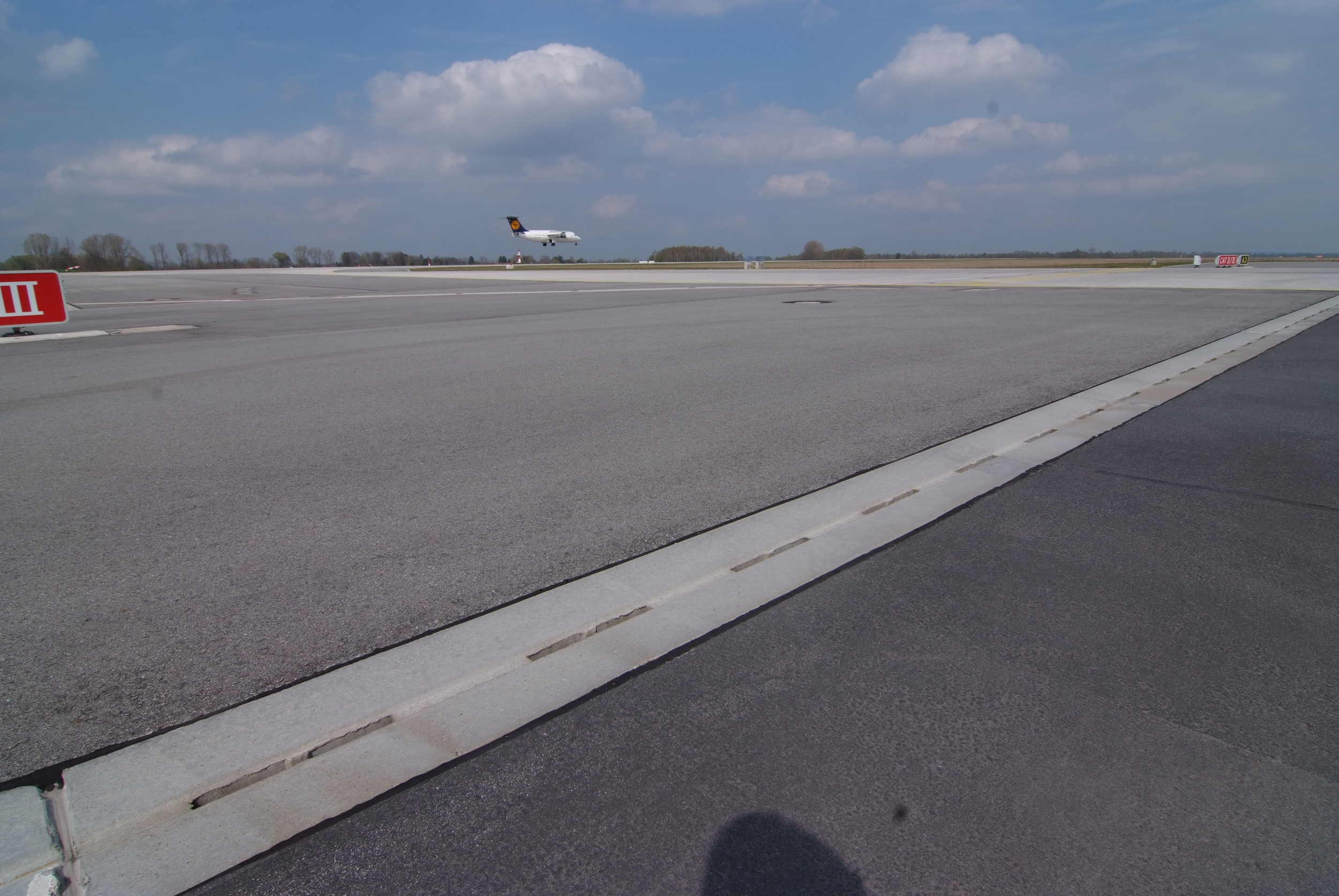 Flugzeug hebt von Rollbahn ab bei Sonnenschein