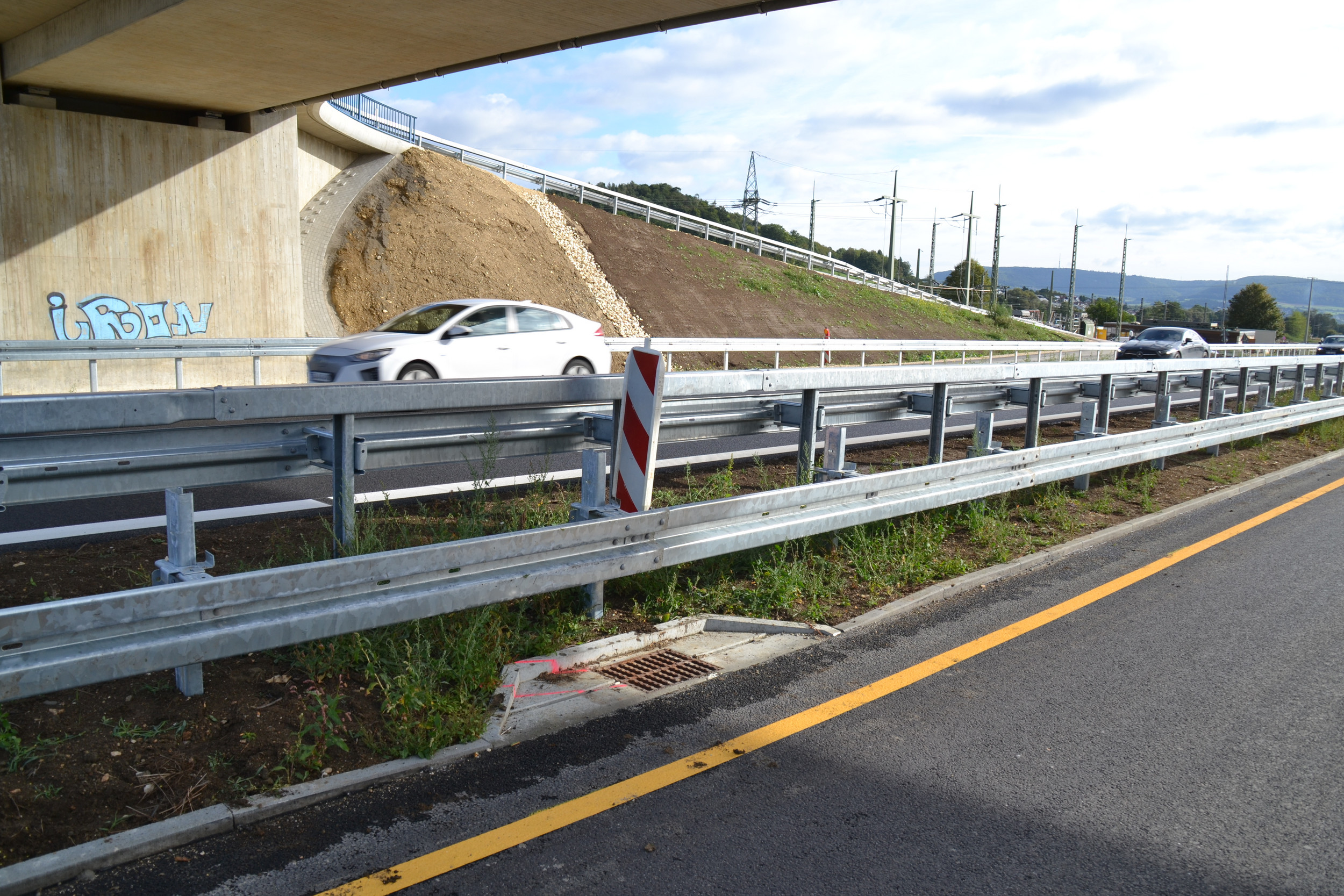 Buchtenentwässerung an der Autobahn unter einer Brücke. Eingebettet in Rasen.