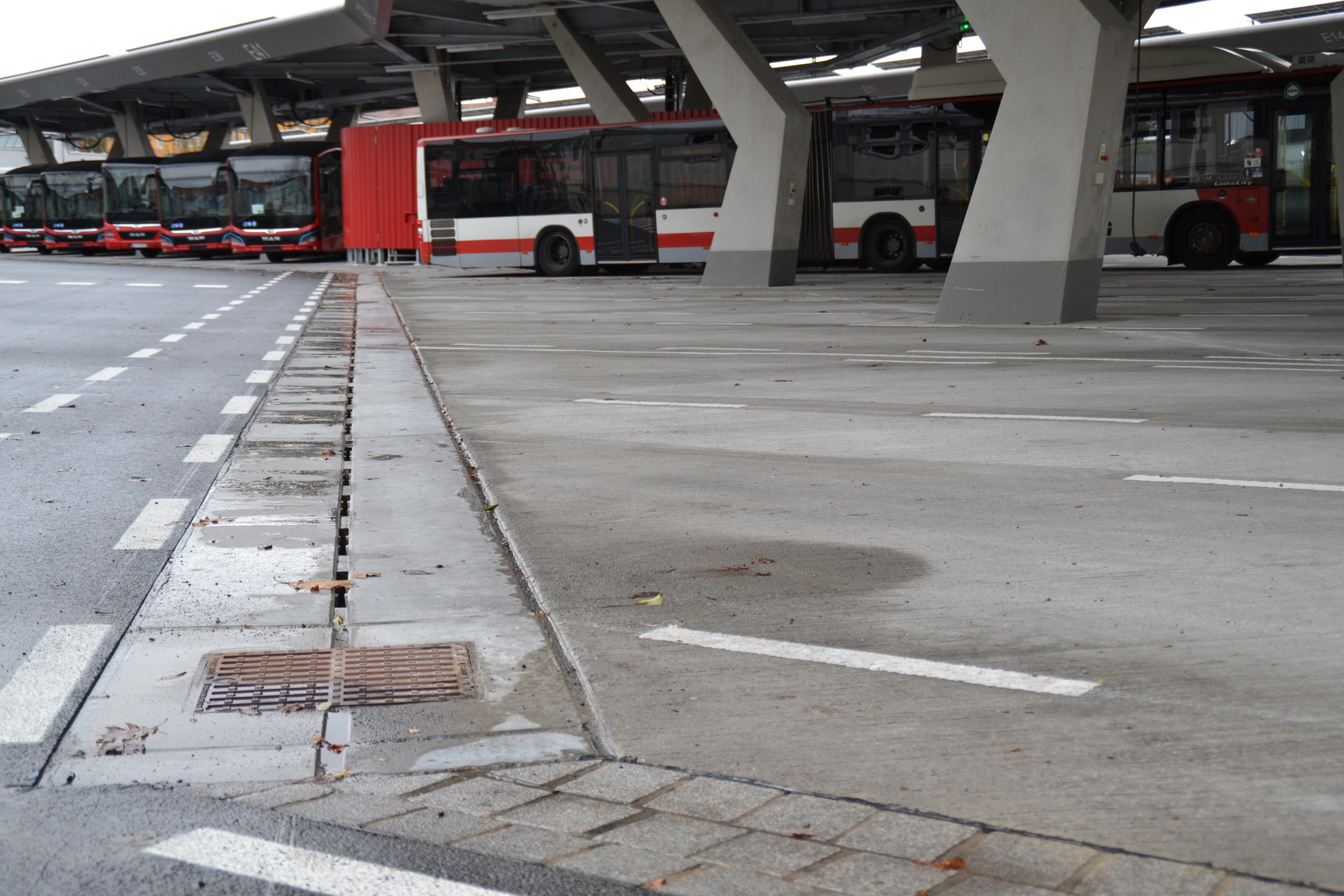Große Bushaltestelle mit parkenden und teilweise abfahrenden/ankommenden Bussen. Pfuhler Rinne ist auf dem Gelände verlegt.